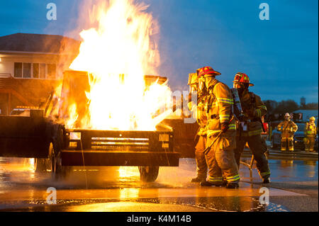 FIREFIGHTERS TRAINING WITH WATER HOSE TO PUT OUT CAR FIRES, LANCASTER PENNSYLVANIA Stock Photo