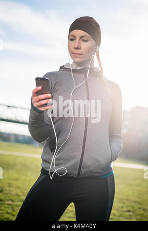 Thoughtful young woman listening to music while wearing trendy s Stock Photo