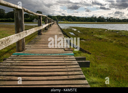 A Wooden footbridge over mudflats at high tide at Aberlady Bay local nature reserve, East Lothian coast, Scotland, UK Stock Photo