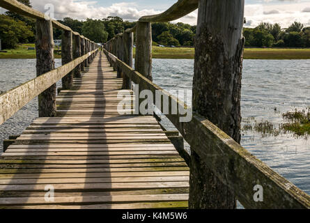 A Wooden footbridge over mudflats at high tide at Aberlady Bay local nature reserve, East Lothian coast, Scotland, UK Stock Photo