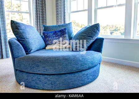 Closeup of new modern blue couch sofa by windows with natural light in home, house or apartment Stock Photo