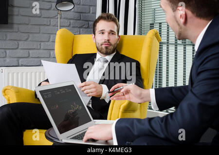 Two focused business partners talking in a modern office Stock Photo