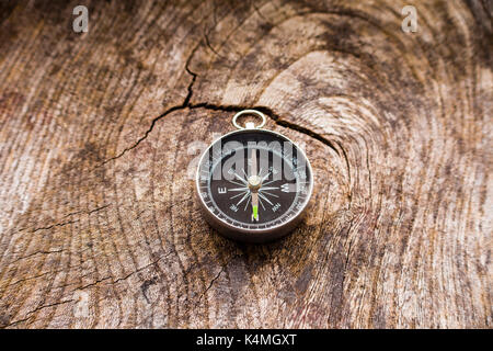 A small portable dry magnetic compass on a grainy wooden background Stock Photo