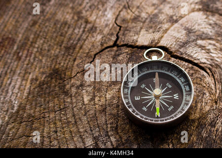 A small portable dry magnetic compass on a grainy wooden background Stock Photo