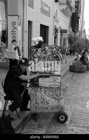 ATHENS, GREECE - JUNE 12, 2015: Man plays vintage portable barrel piano with laterna poverty and pride sign. Traditional street musician in downtown A Stock Photo
