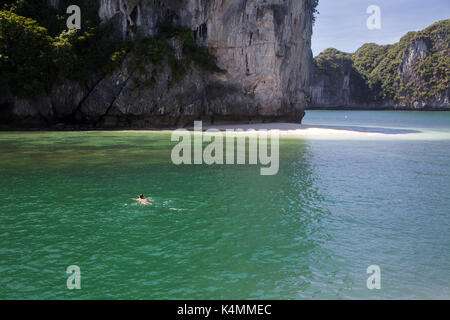 cruising among beautiful limestone rocks and secluded beaches in Ha Long bay, UNESCO world heritage site, Vietnam Stock Photo