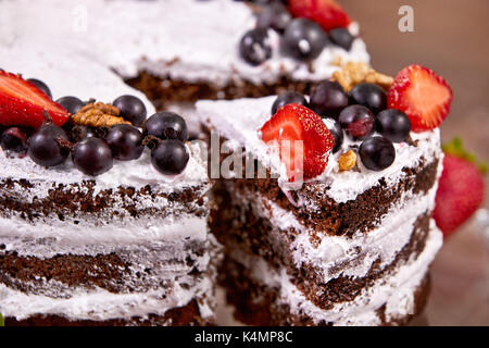 a cut of cake with whipped cream and strawberry fruits on wood table Stock Photo