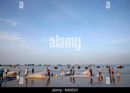 Fishing boats and women sorting fishing catch, Vung Tau Beach, Vietnam, Indochina, Southeast Asia, Asia Stock Photo