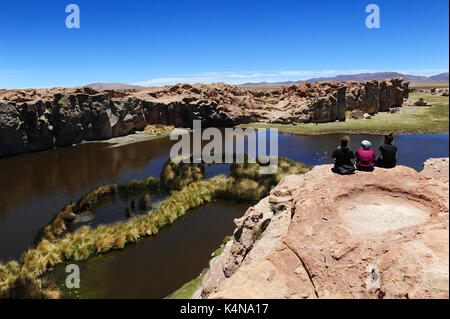 People sitting on a rock overlooking Laguna Negra, Southern Bolivia Stock Photo