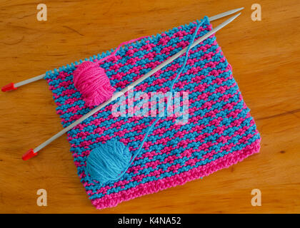 Homemade cotton dishcloths with knitting needles. Stock Photo