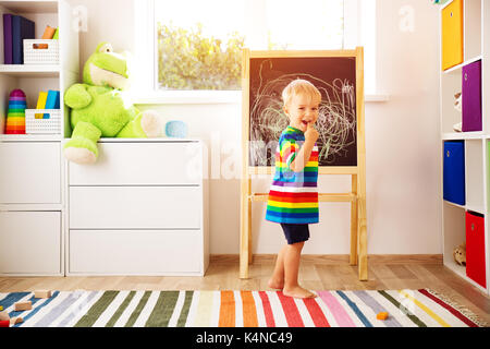 little child drawing on the blackboard Stock Photo