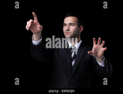 Business man pushing the imaginary  button. Isoladed on black. Stock Photo