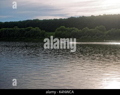 fast rubber boat on the river Oka in the evening, Tula oblast Stock Photo