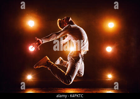 Young man break dancer jumping high in club stage with lights Stock Photo