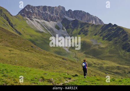 Young femaie trekker hiking on a trail in the Dolomites, Italy, towards the summit of Monte Cavallino on the Austrian border