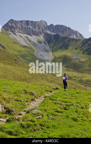 Young femaie trekker hiking on a trail in the Dolomites, Italy, towards the summit of Monte Cavallino on the Austrian border