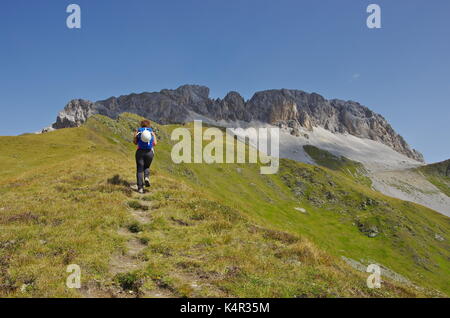 Young femaie trekker hiking on a trail in the Dolomites, Italy, towards the summit of Monte Cavallino on the Austrian border
