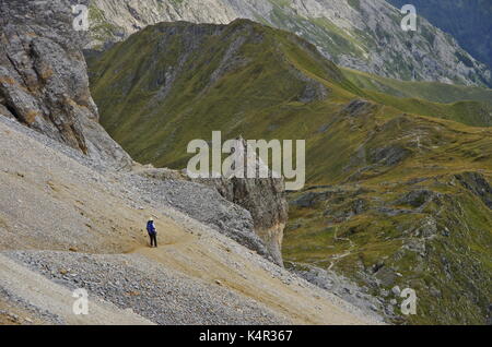 Young femaie trekker hiking on a trail in the Dolomites, Italy