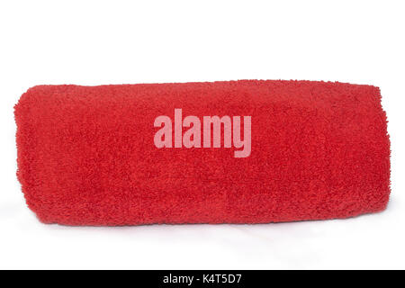 Red single towel rolled up against a plain white and isolating background. Stock Photo