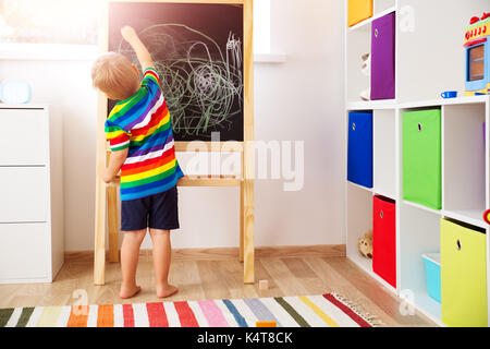 little child drawing on the blackboard Stock Photo