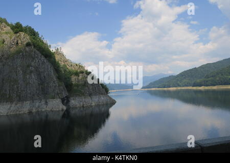 Lake Vidraru, an artificial lake in Fagaras mountains, Romania is reservoir lake created in 1965 on Arges River for electricity production. Stock Photo