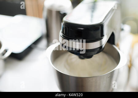 White kitchen machine and stand mixer on a wooden table in a bright design  apartment Stock Photo - Alamy