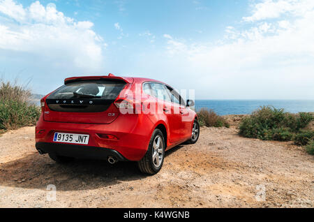 Santa Ponsa, Mallorca, Spain - May 28, 2015: Red car Volvo v40 stands on the edge of a cliff in front of the Mediterranean sea. Morro d'en Pere Joan b Stock Photo