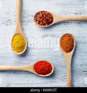 Wooden spoon filled with spices on white painted table Stock Photo