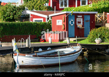 Karlskrona, Sweden - August 28, 2017: Travel documentary of the city surroundings. White open wooden motorboat moored to a pier in front of fishing sh Stock Photo