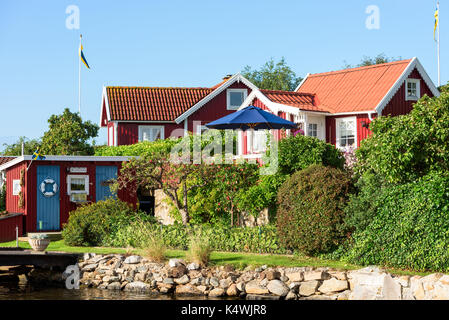 Karlskrona, Sweden - August 28, 2017: Travel documentary of the city surroundings. Seaside garden in coastal allotment area with red and white cabins  Stock Photo