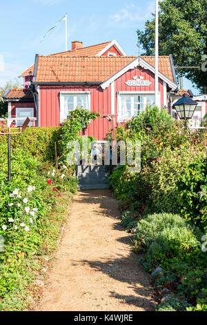 Karlskrona, Sweden - August 28, 2017: Travel documentary of the city surroundings. Allotment with garden lane in front of traditional red and white bu Stock Photo