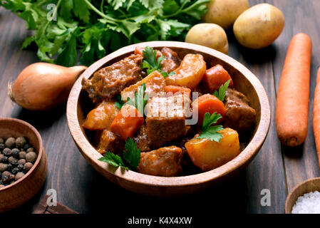 Dish for dinner. Meat stew with vegetables in wooden bowl Stock Photo