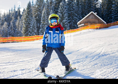 Cute little boy, skiing happily in Austrian ski resort in the mountains, wintertime Stock Photo