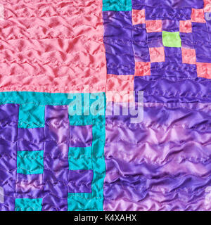 textile background - sewn pieces of fabrics in handmade stitched silk patchwork scarf Stock Photo