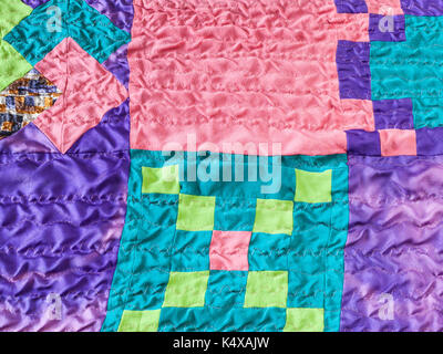 textile background - sewn square pieces of fabrics in stitched silk patchwork scarf Stock Photo