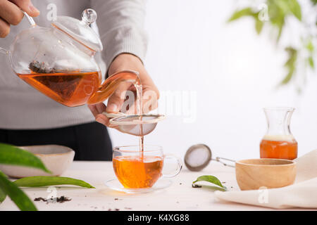 Poured from a teapot cup of tea on a wooden table Stock Photo