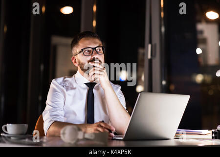 Businessman in the office at night working late. Stock Photo