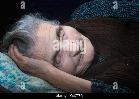 An elderly woman is sleeping in bed Stock Photo