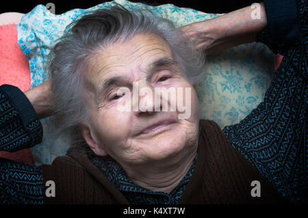 Tired elderly. woman resting on the bed Stock Photo