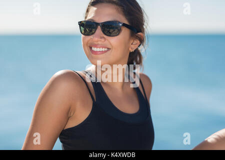 Close up portrait of young happy woman in sunglasses smiling Stock Photo