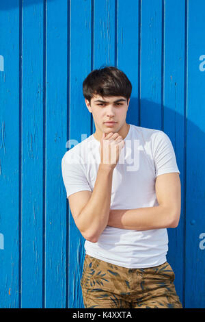 Portrait of young man handsome man standing against blue background Stock Photo