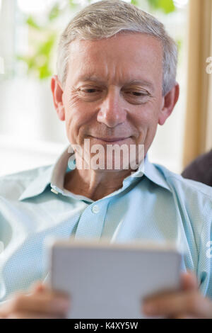 Mature Man Using Digital Tablet At Home Stock Photo