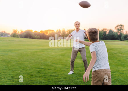 grandfather and grandson playing rugby Stock Photo