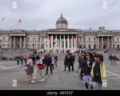 People walk in front of the National Gallery, Trafalgar Square, London, UK. Stock Photo
