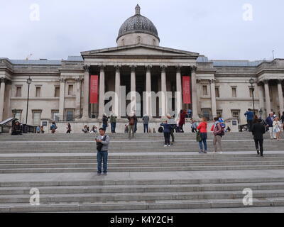 Visitors on the steps outside the National Gallery, Trafalgar Square, London. UK. Stock Photo
