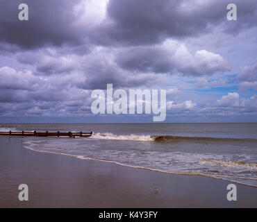 Clouds clearing the beach with wind farm in the background Skegness Lincolnshire England Stock Photo