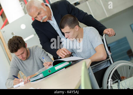 student in wheelchair working in assitance class Stock Photo