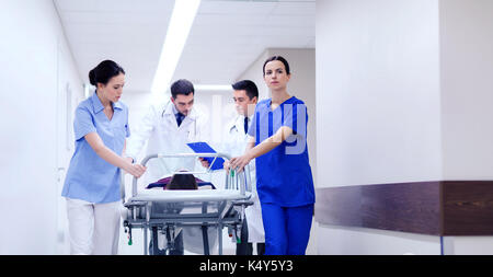 medics with woman on hospital gurney at emergency Stock Photo