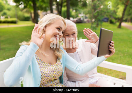 daughter with tablet pc and senior mother at park Stock Photo