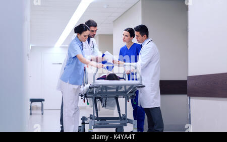 medics with woman on hospital gurney at emergency Stock Photo